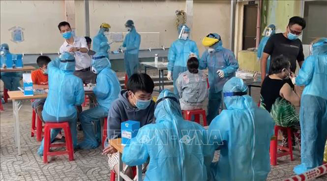  Cán bộ y tế của Trung tâm y tế Quận 1 lấy mẫu xét nghiệm tầm soát cho người dân khu vực Mả Lạng, Phường Nguyễn Cư Trinh, Quận 1. Ảnh: Đinh Hằng/TTXVN