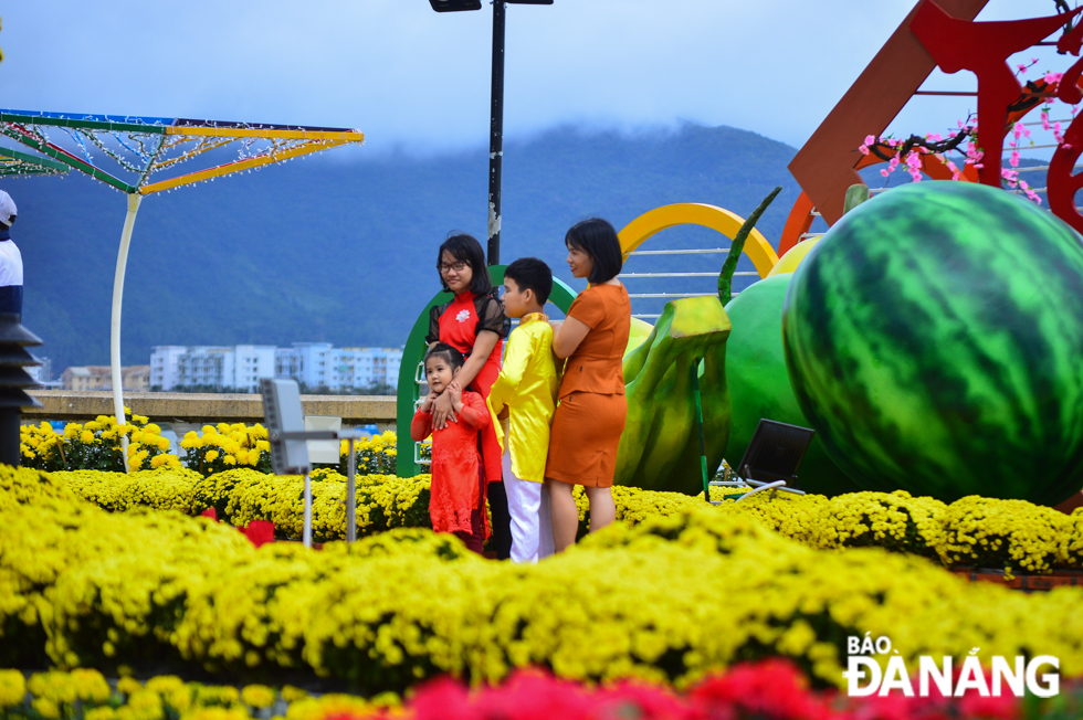 They only are without face coverings as posing for souvenir photos at the Bach Dang flower street