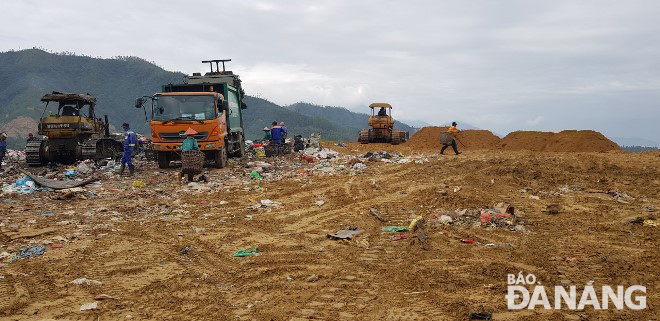 Tại bãi rác Khánh Sơn, rác tươi vừa đổ xuống được san ủi và lấp đất ngay để tránh phát tán mùi hôi về khu dân cư. Ảnh: HOÀNG HIỆP