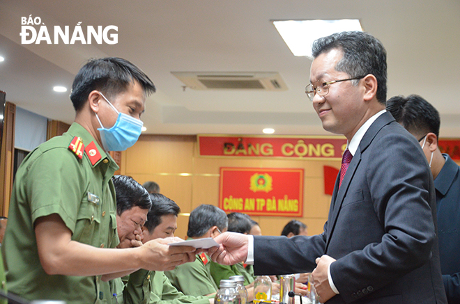 Da Nang Party Committee Secretary Nguyen Van Quang presenting lucky money to the staff of the municipal Police Department