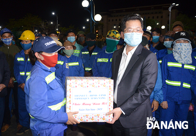 Da Nang Party Committee Secretary Nguyen Van Quang presenting Tet gifts to sanitation workers from the Da Nang Urban Environment JSC who were on duty at the 29 March Square on 2 September Street