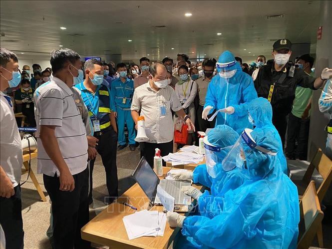 Nhân viên y tế làm thủ tục lấy mẫu xét nghiệm cho người làm việc tại sân bay Tân Sơn Nhất, ngày 6-2-2021. Ảnh: TTXVN phát