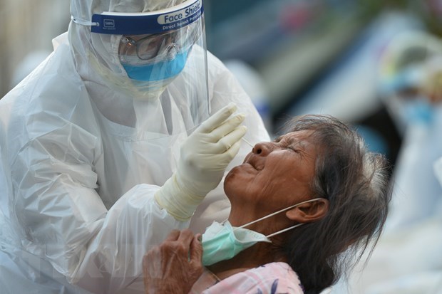 A medical worker takes swab from a woman for COVID-19 testing in Samut Sakhon province of Thailand (Photo: Xinhua/VNA)