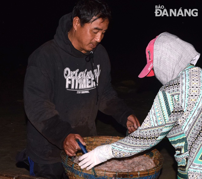 Traders with plastic baskets full of tiny shrimps