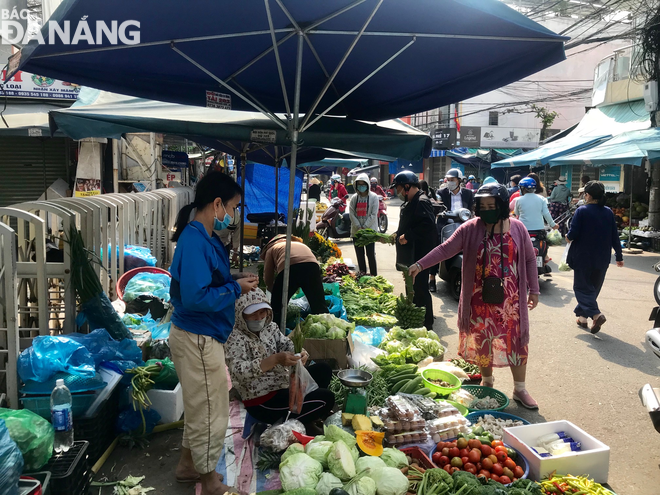 Shoppers buying vegetables at the Dong Da Market