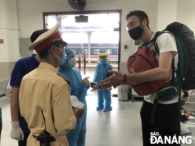 functional local forces, including medical workers and police officers, plus Youth Union members performing coronavirus prevention tasks at the Da Nang railway station during Tet