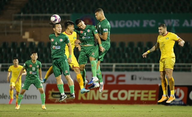 Players compete in the match between Sài Gòn FC (in green) and Sông Lam Nghệ An in the third round match of the V.League 1 tournament on January 30. Although the COVID-19 forced a delay of the tournament one official has promised football would soon return. Photo courtesy of VPF