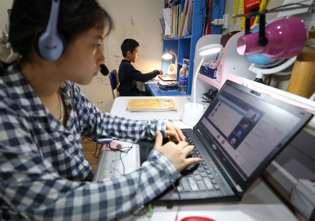 Two siblings in Ha Noi attend online classes. — VNA/VNS Photo 