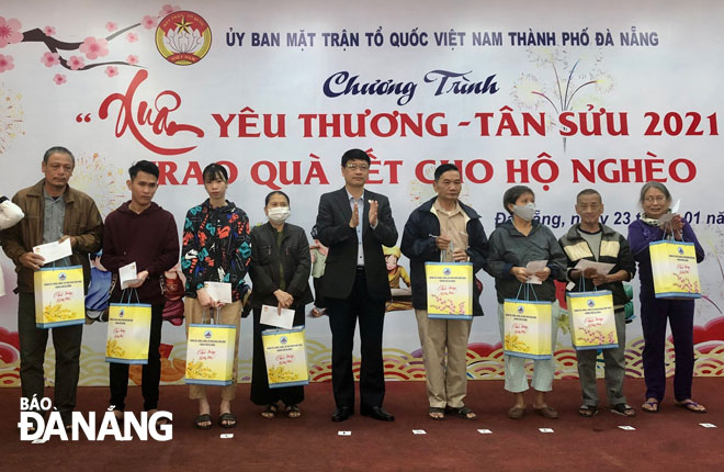 Chủ tịch Ủy ban MTTQ Việt Nam thành phố Ngô Xuân Thắng (giữa) trao quà Tết cho hộ nghèo tại Chương trình “Xuân yêu thương” diễn ra vào ngày 23-1-2021.Ảnh: NGUYỄN QUANG