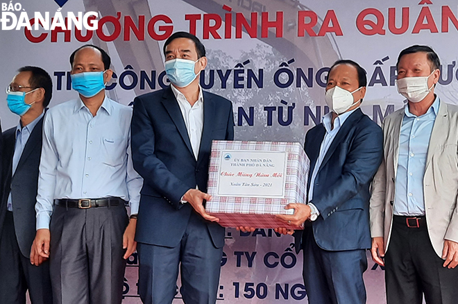 Chủ tịch UBND thành phố Lê Trung Chinh (thứ 3 từ trái sang) trao tặng quà Tết Tân Sửu đến chủ đầu tư và nhà thầu thi công xây dựng tuyến ống cấp nước phân phối đối với Nhà máy cấp nước Hòa Liên. Ảnh: TRIỆU TÙNG