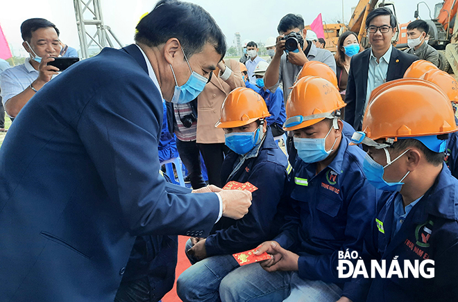 Chairman Chinh giving lucky money to construction workers at the construction site of the Co Co River dredging project