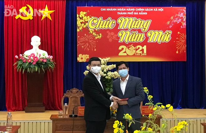 Vice Chairman Minh (left) giving a gift to leader of the Da Nang branch of the Viet Nam Bank for Social Policies