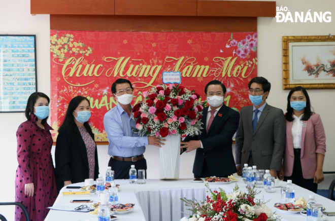  Municipal People’s Council Vice Chairman Le Minh Trung (3rd right) presenting a bouquet of flowers to the Thuan Phuoc Company representatives 
