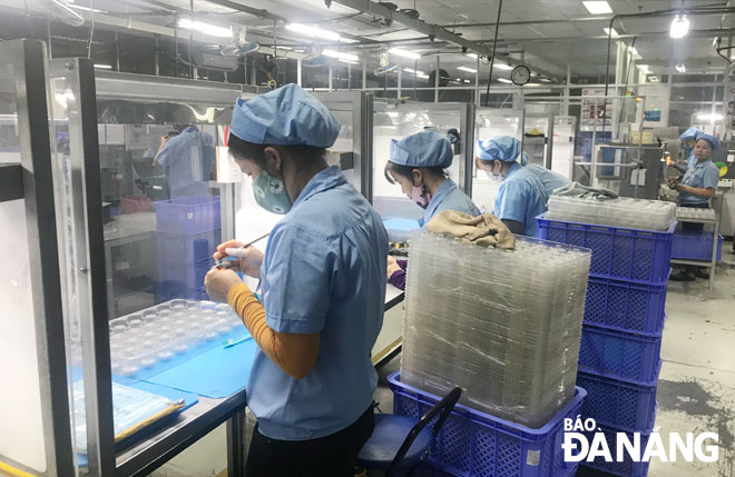 Workers at the Daiwa Vietnam Co., Ltd are seen keeping safe distance from others at work