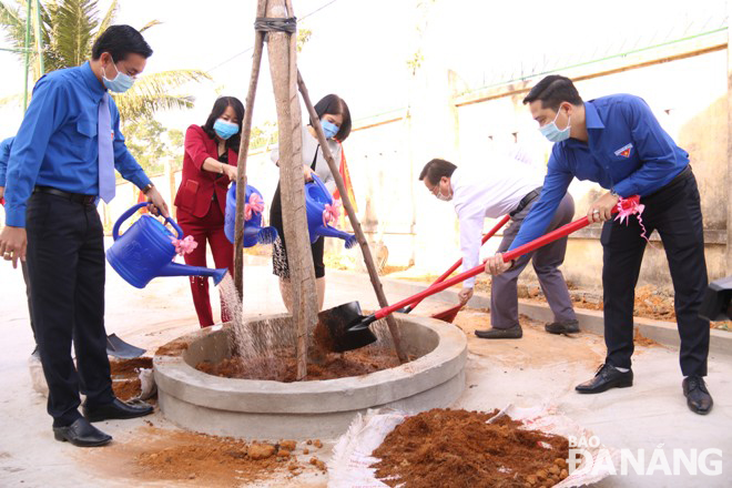 Delegates planting trees at the Le Van Tam Primary School following the launching ceremony