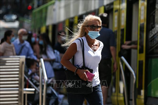 Người dân đeo khẩu trang phòng lây nhiễm Covid-19 tại Melbourne, Australia, ngày 12-2-2021. Ảnh: AFP/TTXVN