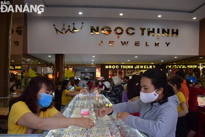  All customers and staff at a gold shop on Trung Nu Vuong Street are seen wear face masks during transactions.