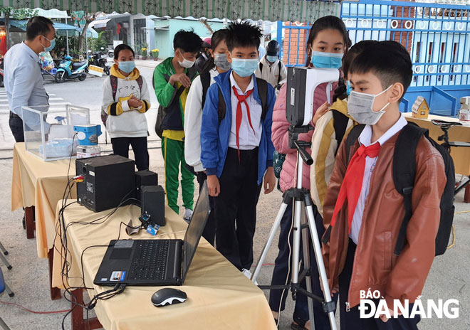 Pupils at Da Nang-based Luong The Vinh Junior High School are seen having their body temperature measured at the entrance gate.