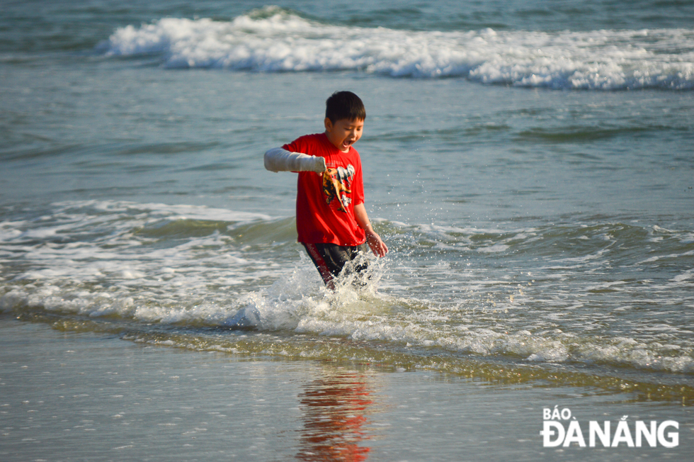 Children excitedly play on a beach.