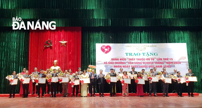  Da Nang Party Committee Secretary Nguyen Van Quang and municipal People's Council Vice Chairman Le Minh Trung honour the ‘Meritorious Physicians’ title holders on Friday morning.