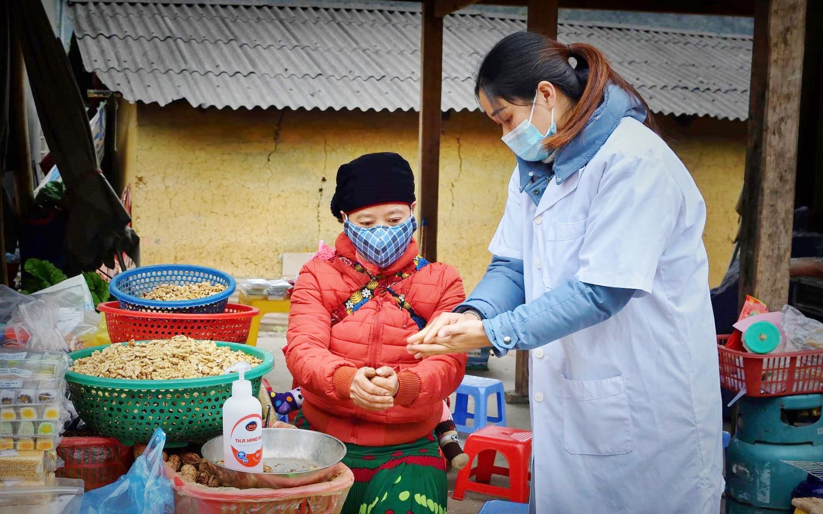 Hướng dẫn bà con tiểu thương rửa tay sát khuẩn tại chợ phiên Sà Phìn (Đồng Văn, Hà Giang). Ảnh: BYT