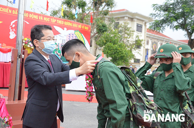 Da Nang Party Committee Secretary Nguyen Van Quang presenting congratulatory bouquets to new recruits at the Hoa Vang District departure point