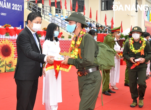 Da Nang Party Committee Deputy Secretary cum Chairman of the municipal People’s Council Luong Nguyen Minh Triet presenting congratulatory bouquets and gifts to new recruits at the Son Tra District departure point