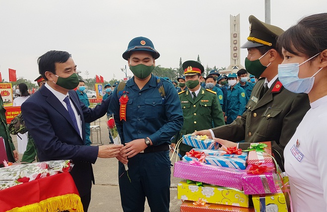 Da Nang People’s Committee Chairman Le Trung Chinh presenting congratulatory bouquets and extending his words of great encouragement to recruits at the Hai Chau District departure point