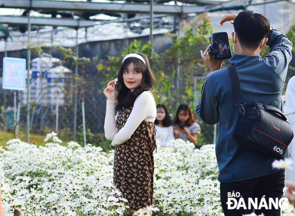 A young beautiful girl posing for a photo with daisies 