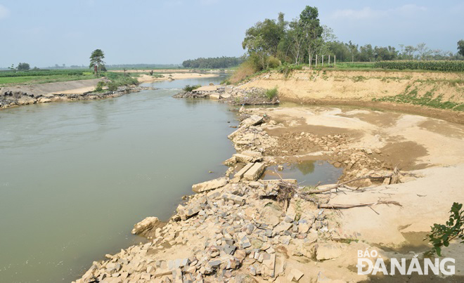 Sông Quảng Huê stại cửa điều tiết nước bị sạt lở nặng nề làm nước sông Vu Gia chảy xiết về sông Thu Bồn. Ảnh: HOÀNG HIỆP