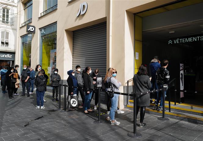 Người dân đeo khẩu trang phòng lây nhiễm COVID-19 khi xếp hàng bên ngoài một cửa hiệu ở Nice, Pháp, ngày 23/2/2021. Ảnh: THX/ TTXVN