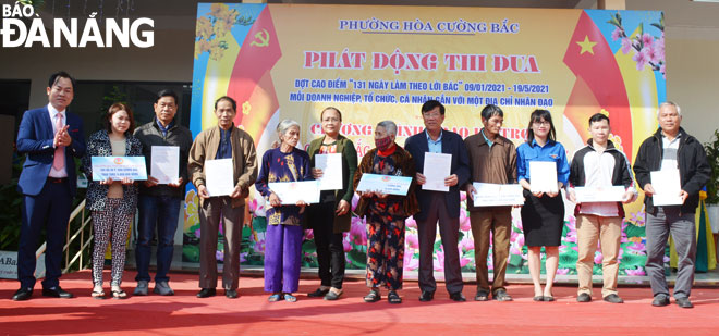 Các hộ nghèo phường Hòa Cường Bắc nhận bảng hỗ trợ tại buổi phát động phong trào thi đua chào mừng kỷ niệm 131 năm Ngày sinh Chủ tịch Hồ Chí Minh. (Ảnh chụp tháng 1-2021) Ảnh: LÊ VĂN THƠM