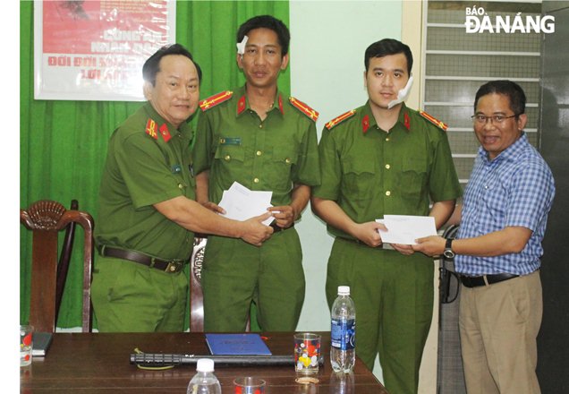 Chủ tịch UBND quận Sơn Trà Hoàng Sơn Trà (ngoài cùng bên phải) thăm hỏi, động viên 2 cán bộ, chiến sĩ bị thương khi làm nhiệm vụ. Ảnh: L.HÙNG