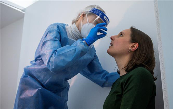 Nhân viên y tế lấy mẫu xét nghiệm Covid-19 tại Berlin, Đức. Ảnh: AFP/TTXVN