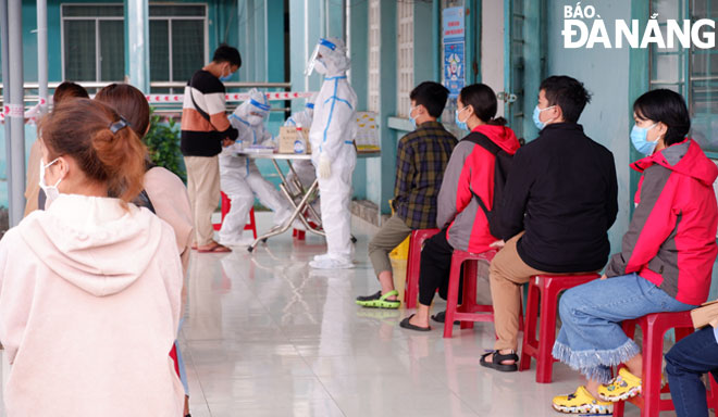 Students and workers in Ngu Hanh Son District waiting for random sampling for SARS-CoV-2 testing on Wednesday morning.