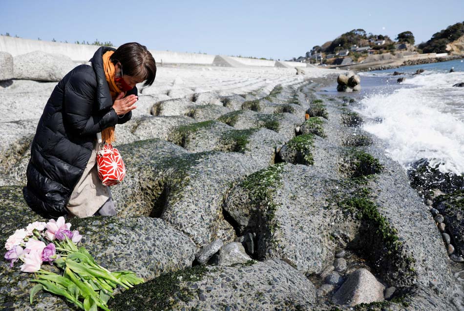 Một người dân cầu nguyện tại bờ biển tưởng niệm các nạn nhân của trận động đất và sóng thần khiến hàng nghìn người thiệt mạng cách đây 10 năm. Ảnh: Reuters