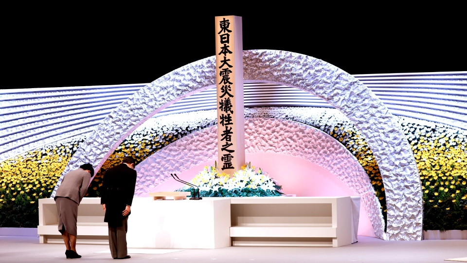 Nhật hoàng Naruhito và Hoàng hậu Masako cúi đầu trước đài tưởng niệm các nạn nhân tại Tokyo ngày 11-3-2021. Ảnh: AP