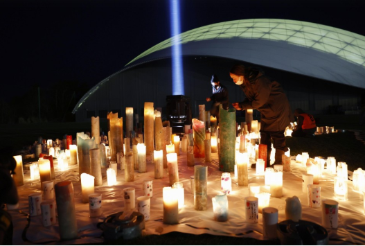 Nến được thắp sáng tại trung tâm huấn luyện bóng đá J-Village ở tỉnh Fukushima trong một sự kiện tưởng niệm các nạn nhân của trận động đất-sóng thần cách đây 10 năm. Ảnh: Kydo