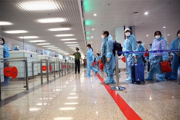 Travellers line up for procedures at an airport before entering Vietnam. (Photo: VNA)