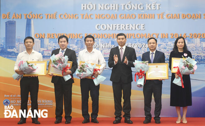 Municipal People's Committee Vice Chairman Ho Ky Minh (3rd, from right) presenting certificates of merit from the municipal government to 6 units and 4 individuals in recognition of their excellent achievements in the implementation of the city’s economic diplomacy over the 2016 - 2020 period.