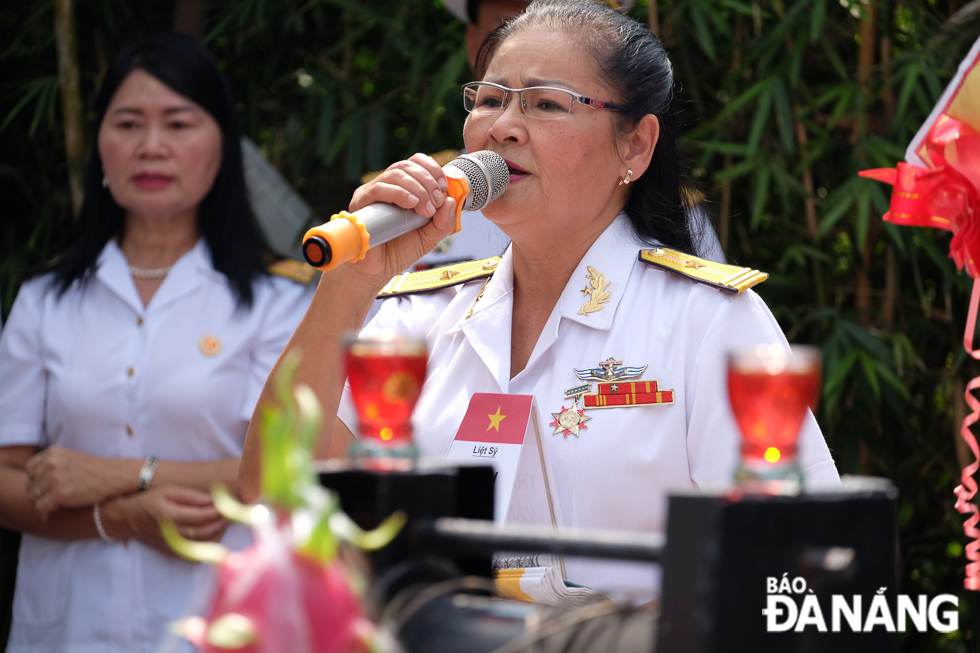 Thiếu tá Nguyễn Thị Bích Lạc - vợ của liệt sĩ Trần Văn Phòng vừa cầm bài vị chồng vừa hát ca khúc 