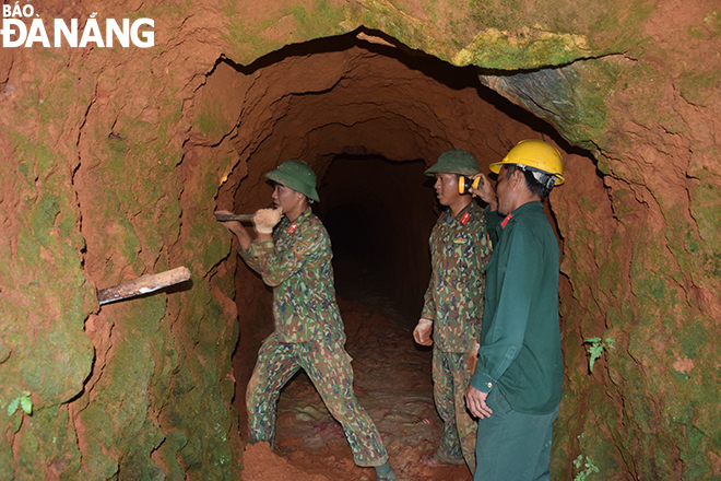 Các cán bộ, chiến sĩ đào, đục các lỗ ở vách hầm vàng ở khu vực Khe Đương để đặt thuốc nổ đánh sập hầm. Ảnh: HOÀNG HIỆP