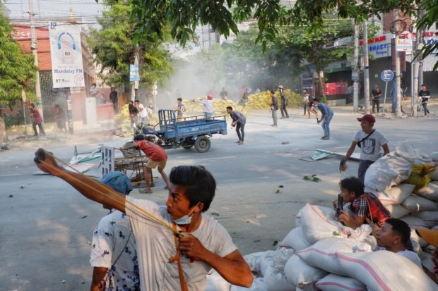 Người biểu tình dùng súng cao su chống trả lực lượng an ninh Myanmar ngày 14/3. Ảnh: Reuters