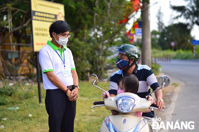 Volunteer Le Kha Thien in white T-shirt) reminding a resident not to feed monkeys in front of the Doi Temple site