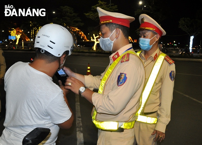 Lực lượng Cảnh sát giao thông kiểm tra nồng độ cồn người điều khiển phương tiện lưu thông trên đường phố. Ảnh: L.HÙNG