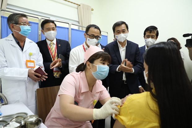 Deputy Minister of Heath Tran Van Thuan (second from right) inspects the vaccination of COVIVAC on a volunteer (Photo: VNA)