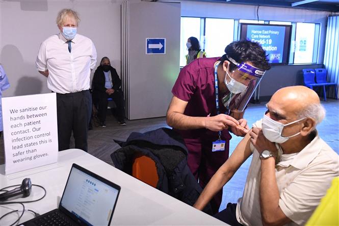 Thủ tướng Anh Boris Johnson (trái) thị sát việc tiêm phòng vaccine ngừa COVID-19 Oxford/Astrazeneca tại The Hive, phía Bắc London, ngày 25/1/2021. Ảnh: AFP/TTXVN