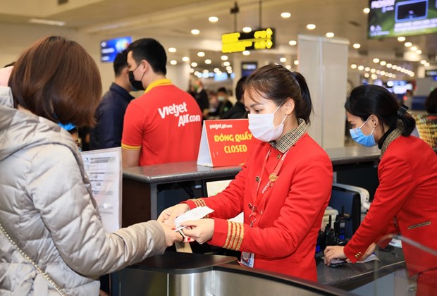 A Vietjet employee helps a passenger to handle boarding procedures (Photo: Vietjet)