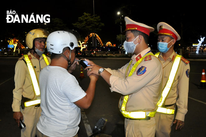 Tổ công tác thuộc Phòng Cảnh sát giao thông, Công an thành phố kiểm tra nồng độ cồn người điều khiển phương tiện trên đường (ảnh chụp tối 15-3). Ảnh: Lê HÙNG