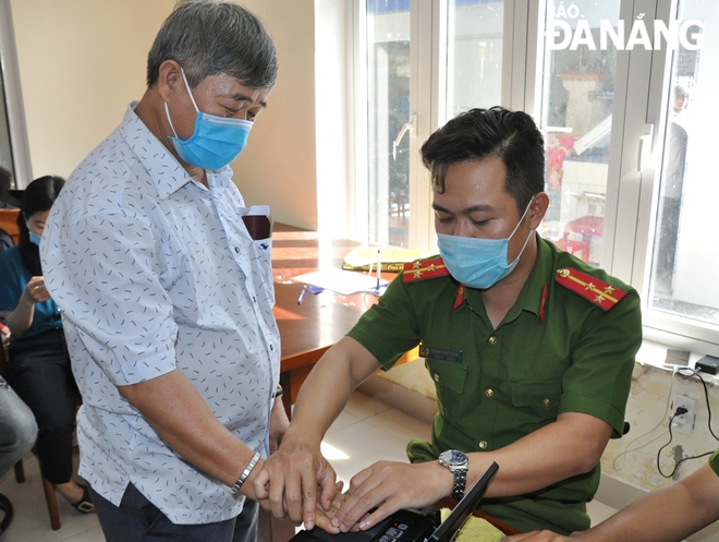 Cam Le District police taking fingerprint samples from chip-based ID card applicants on Friday morning